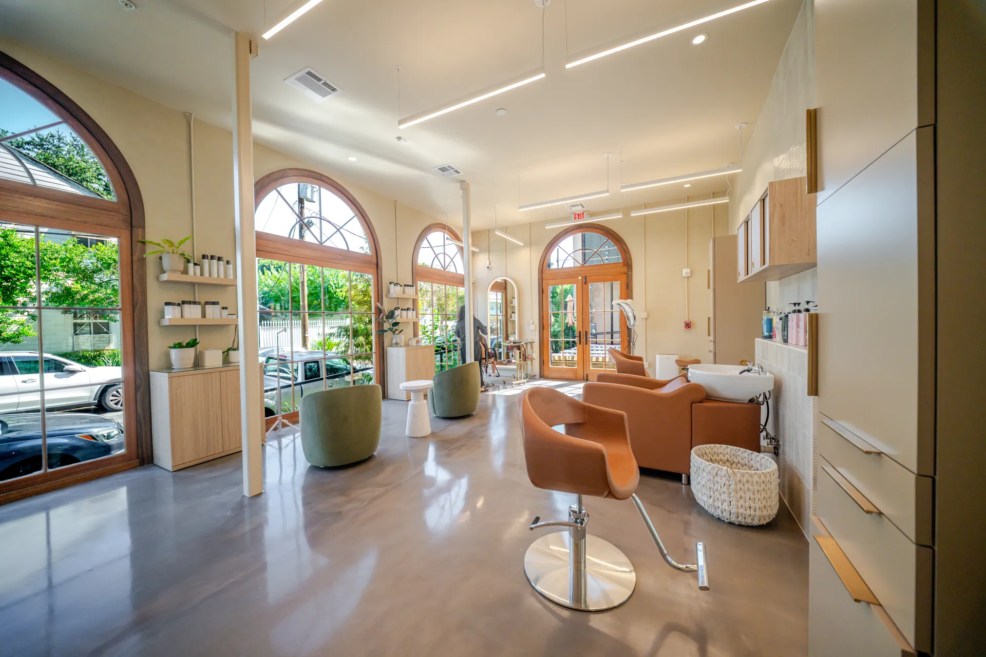 Polished bronze epoxy floor in a salon with arched windows and natural light
